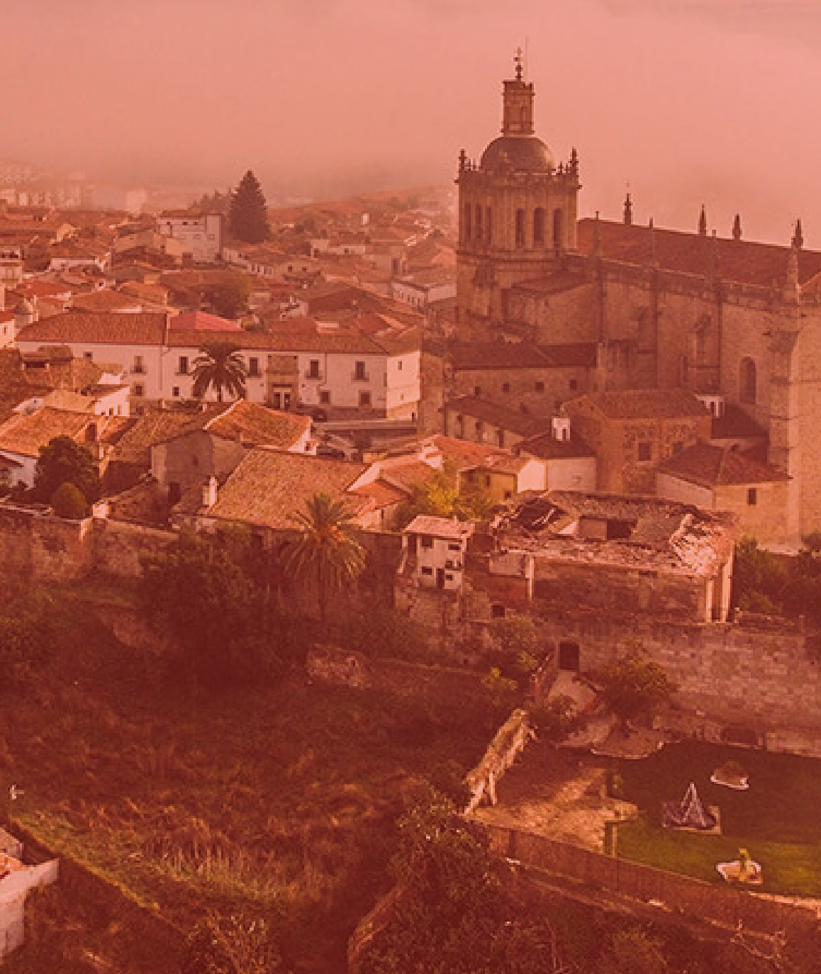 Vista aérea de la Plaza de San Jorge en Cáceres con el texto CÁCERES sobre impreso y filtro rojizo.